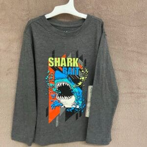 A gray long sleeve shirt with shark and shark fin designs.