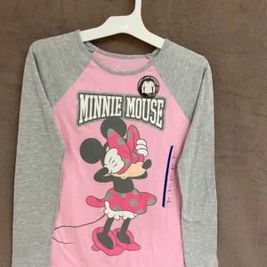 A pink and gray minnie mouse shirt hanging on a clothes rack.