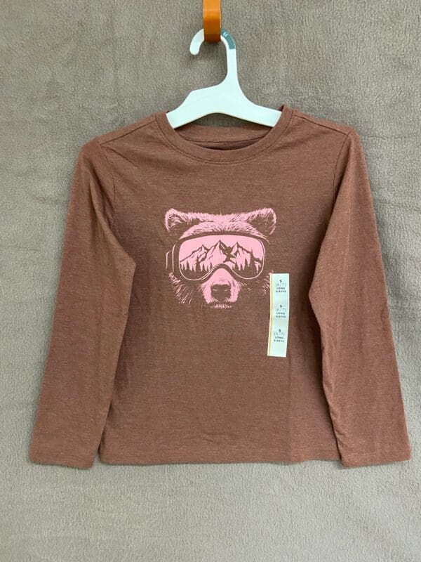 A brown long sleeve shirt with a pink bear on it.