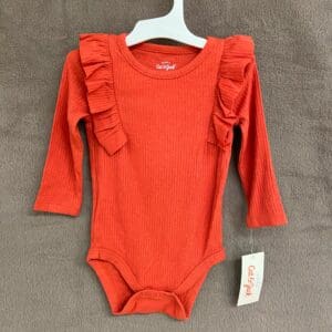 A red long sleeve onesie with ruffles on the front.