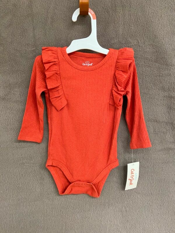 A red long sleeve onesie with ruffles on the front.